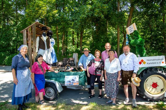 Der Umzugswagen mit Torfh&uuml;tte und Karren mit Torf von einem Tracktor gezogen